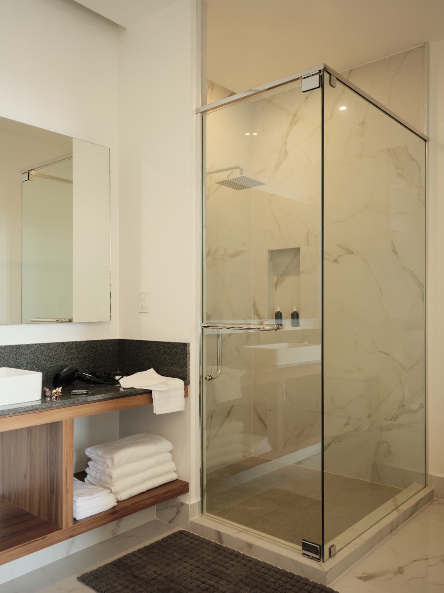 Baño con regadera de lluvia y acabados en mármol